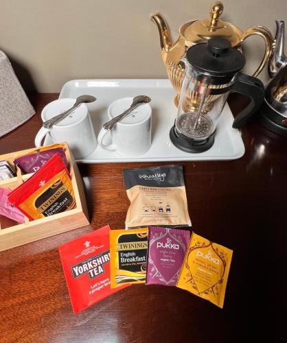 a table with a tray of food and a tea kettle at Uplands Guest House in Ledbury