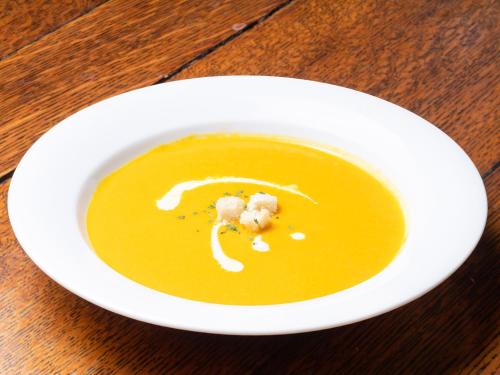 a white bowl of soup on a wooden table at Gasthof Ami in Nikko