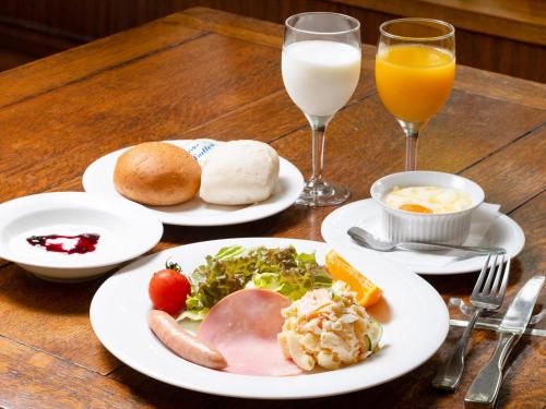 a table with plates of food and two glasses of milk at Gasthof Ami in Nikko