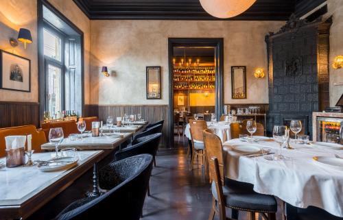 a restaurant with tables and chairs with white tablecloths at Communal Hotel Kutaisi in Kutaisi