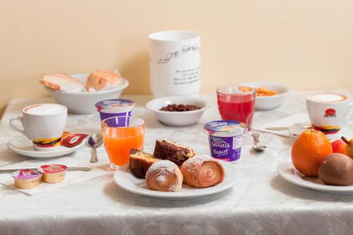 a table with breakfast foods and drinks on it at Hotel Luca in Valverde