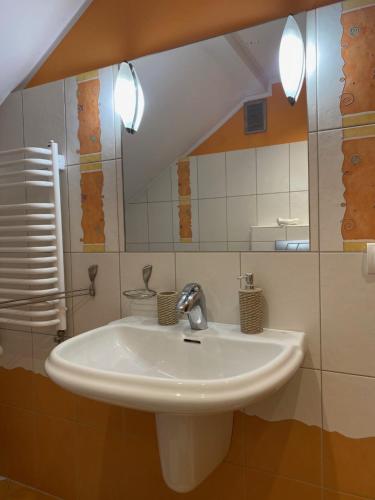 a bathroom with a white sink and a mirror at Apartamenty Plac Moniuszki 11 City Center in Kielce