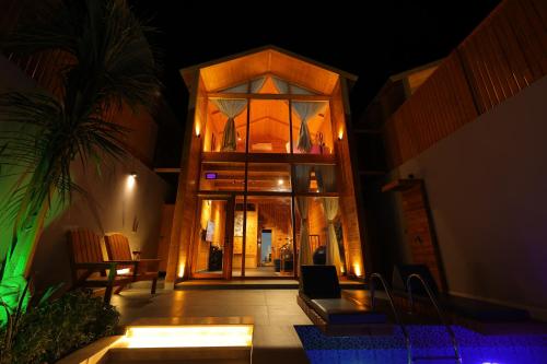 a house with a large glass door at night at أكواخ البحيرات in Khalij Salman