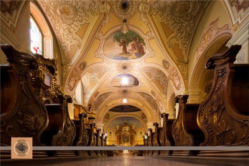 a large church with ornate ceilings and a hallway at Hotel Főnix in Pécs