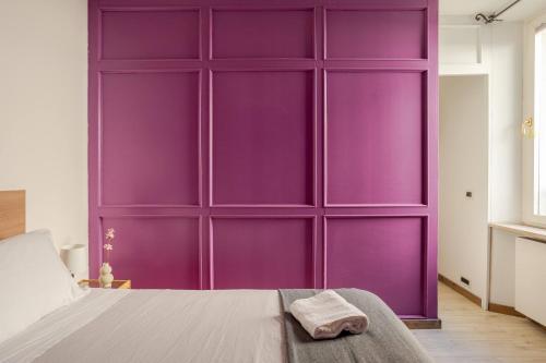 a purple wall in a bedroom with a bed at PuRPLE HoUSE CEntro STOriCO UDinE in Udine