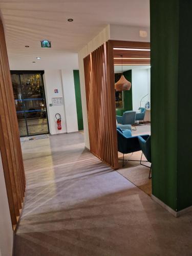 un couloir avec un bureau et des chaises dans un bâtiment dans l'établissement le phenix hôtel limoges, à Limoges