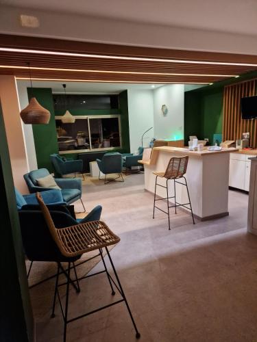 - un salon avec des chaises et un comptoir dans la pièce dans l'établissement le phenix hôtel limoges, à Limoges