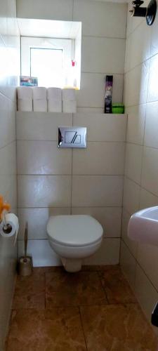 a bathroom with a white toilet and a sink at Dom Pod Gruszą in Chmielno