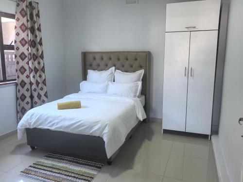 a bedroom with a large bed with white sheets and pillows at Gift Guest house 2 in Cravenby