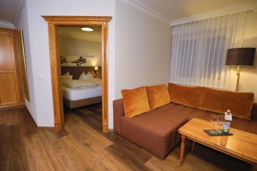 a living room with a couch and a bed at Garden & SPA Hotel Das Götzfried in Regensburg