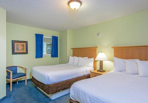 a hotel room with two beds and a chair at Paradise Resort in Myrtle Beach