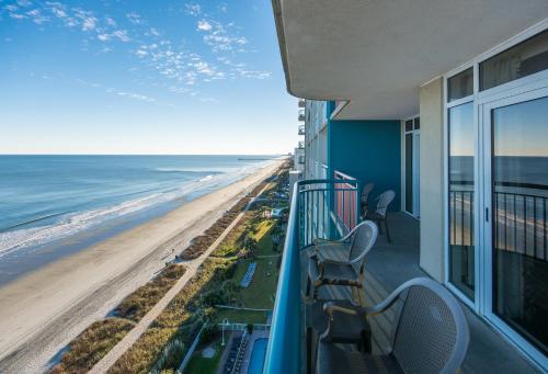 a balcony with chairs and a view of the beach at Paradise Resort in Myrtle Beach