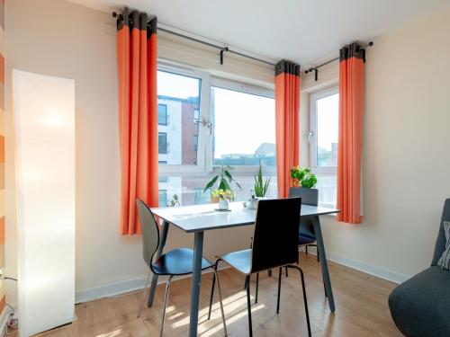 a dining room with orange curtains and a table and chairs at Modern 2-Bdr Flat in Edinburgh - Pass the Keys in Edinburgh