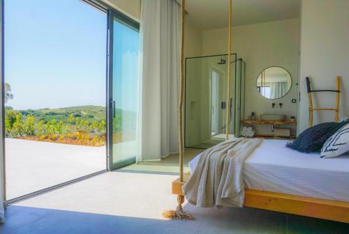 スパルティアにあるMelia by Vintage Travelのベッドルーム1室(ベッド1台付)、大きなスライド式ガラスドアが備わります。