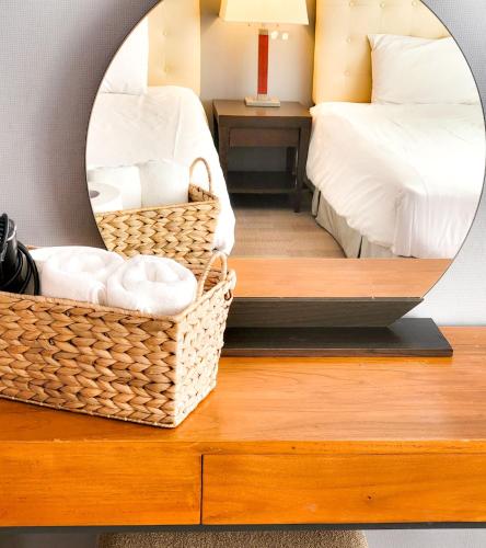 a mirror on a dresser with two beds in a bedroom at Jeju EQ Stay in Jeju