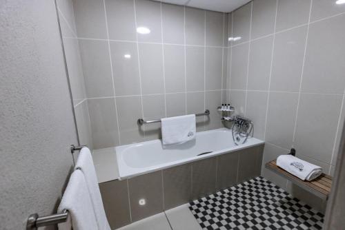 a bathroom with a bath tub and a sink at Hotel 247 @ White River in White River