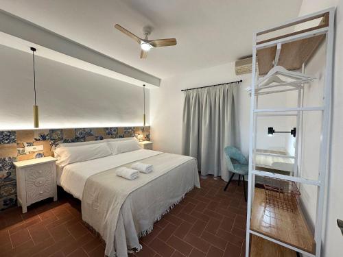 a bedroom with a white bed and a glass door at La Alcazaba de Triana in Seville