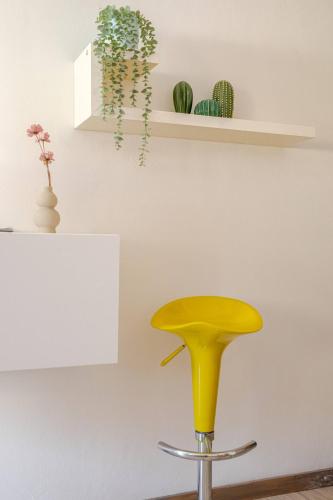 a yellow stool sitting in front of a room at OPEN SPACE cenTro StoRIco UDinE in Udine