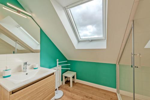 a bathroom with a sink and a skylight at Ty Line - Plage à 300 m 1 500 m² de jardin in Lampaul-Plouarzel