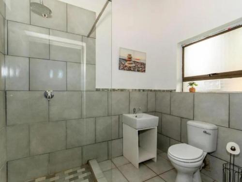 a bathroom with a toilet and a sink at Woodpecker's Guest House in Hazyview