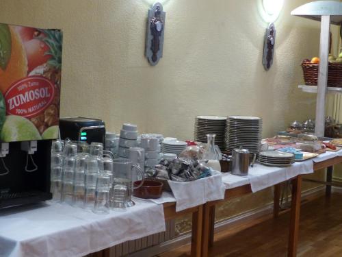 a table with a bunch of glasses and plates on it at Hotel Vall d´Aneu in Esterri d'Àneu