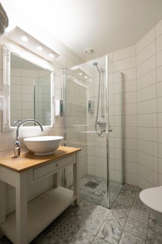 a white bathroom with a sink and a shower at Flåmsbrygga Hotel in Flåm