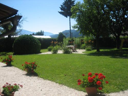 a garden with red flowers in the grass at Villa Martiny in Seeboden