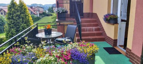 a balcony with a table and a bunch of flowers at Dom Pod Gruszą in Chmielno