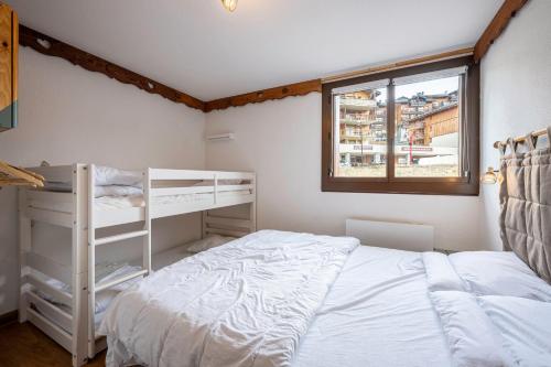 a bedroom with a white bed and a window at Bel Appartement Au Pied Des Pistes in Saint-François-Longchamp