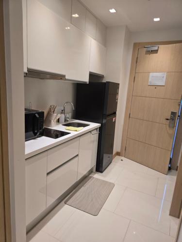 a kitchen with white cabinets and a sink and a refrigerator at The beach front Condo in Ban Saiyuan (1)