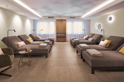 a large living room with couches and tables at Hotel Pistono in Dieblich