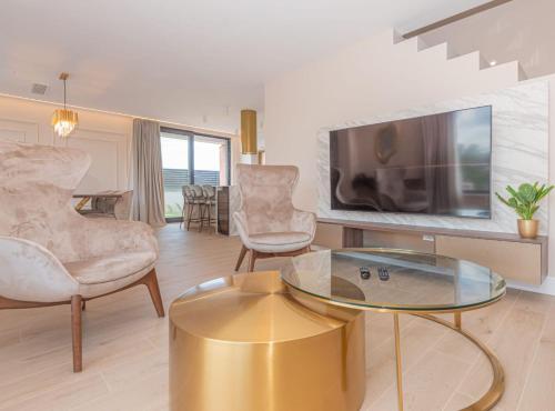 a living room with a gold table and chairs at Villa Šimun Zaton in Zaton