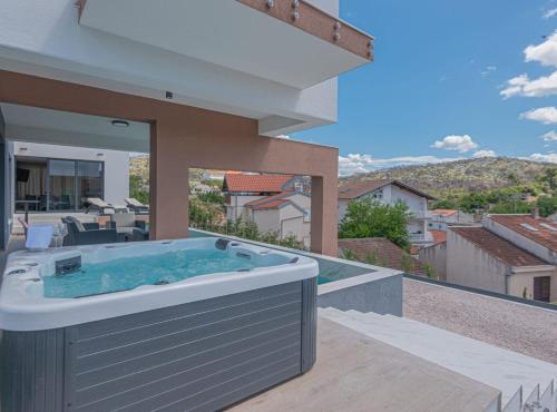 a hot tub on the balcony of a house at Villa Šimun Zaton in Zaton