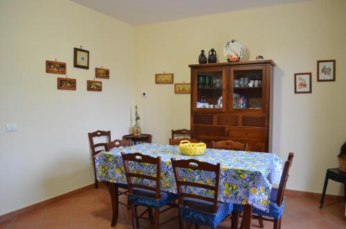 a dining room with a table with chairs and a cabinet at Aspra Mare House in Aspra