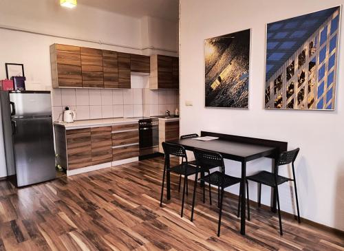 a kitchen with a table and chairs and a refrigerator at Apartament Premium in Krakow