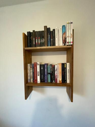 a book shelf hanging on a wall with books at Flat near Strasbourg in Offendorf