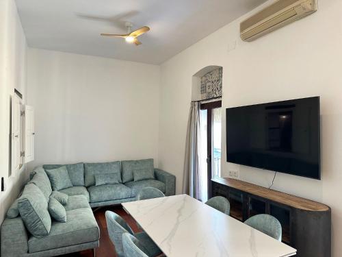 ein Wohnzimmer mit Sofa und Fernseher in der Unterkunft La Alcazaba de Triana in Sevilla