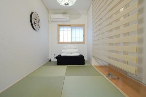 大阪市にある楓の宿3号館のベッドと壁に時計がある部屋