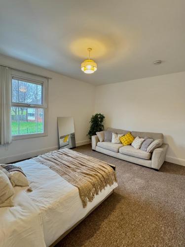a large bedroom with a large bed and a couch at Double Bedroom in Birmingham Near City Center in Birmingham