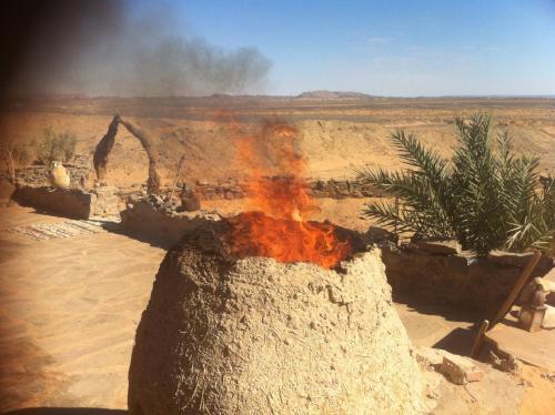 a fire in a pot in the desert at Maison Boutchrafine in Erfoud