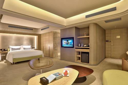 a hotel room with a bed and a tv at Elegant International Hotel Shanghai - Bund Sichuan Road North Metro Station Branch in Shanghai