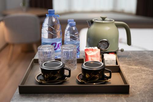 a tray with two coffee cups and water bottles at Elegant International Hotel Shanghai - Bund Sichuan Road North Metro Station Branch in Shanghai
