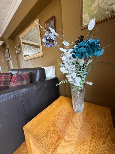 a vase of blue flowers sitting on a table at Springfield oaks cottage in Newport