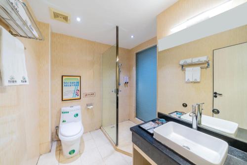 Un baño con inodoro, lavabo y ducha. en Fanbo Hotel, en Zhongshan