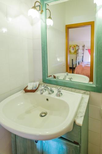 a bathroom with a white sink and a mirror at Locanda di CasalMustia in Castelmuzio