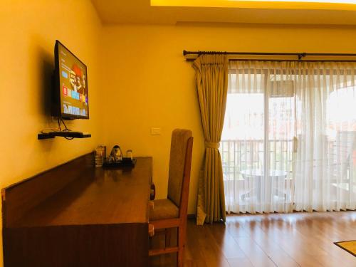 a living room with a television and a table and a window at Manigram Bishram Batika Pvt Ltd in Bhairahawa