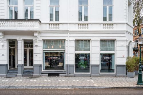 a white building with windows on a city street at Leonardo Boutique Hotel Maastricht City Center in Maastricht