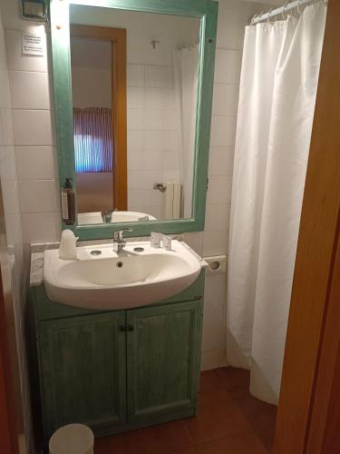 a bathroom with a green sink and a mirror at Locanda di CasalMustia in Castelmuzio