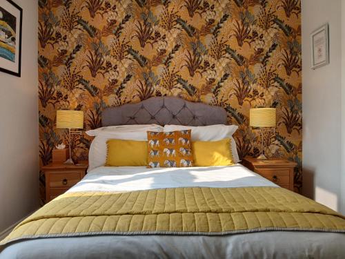 a bedroom with a bed with a floral wallpaper at The Briarfields in Torquay