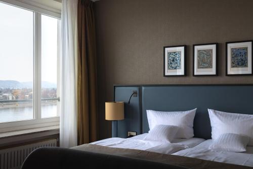 a bedroom with a large bed with a window at AMERON Bonn Hotel Königshof in Bonn